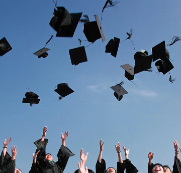 students throwing their motor boards in the air at graduation