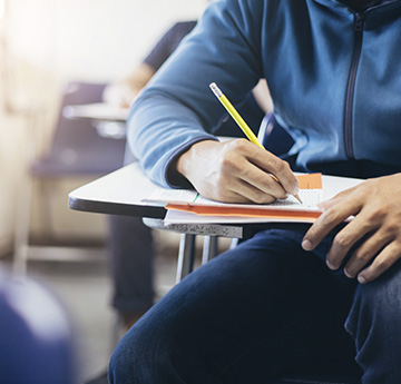 Student sitting at exam desk writing