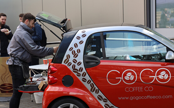 Photo of student with car used for his business