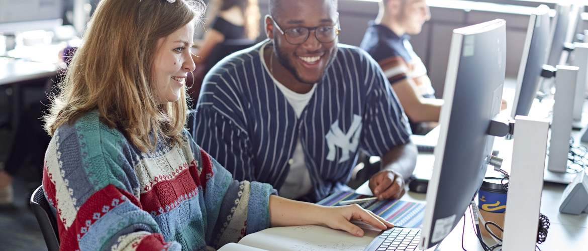 Female and male looking at computer, smiling