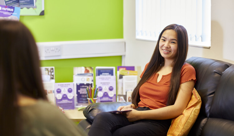 Student sitting on a sofa chatting