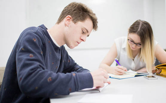 Two students studying together in a classroom. 