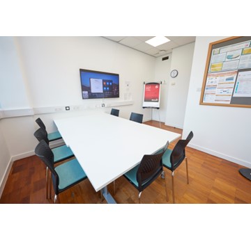 Image of room with tables and chairs and interactive touch screen