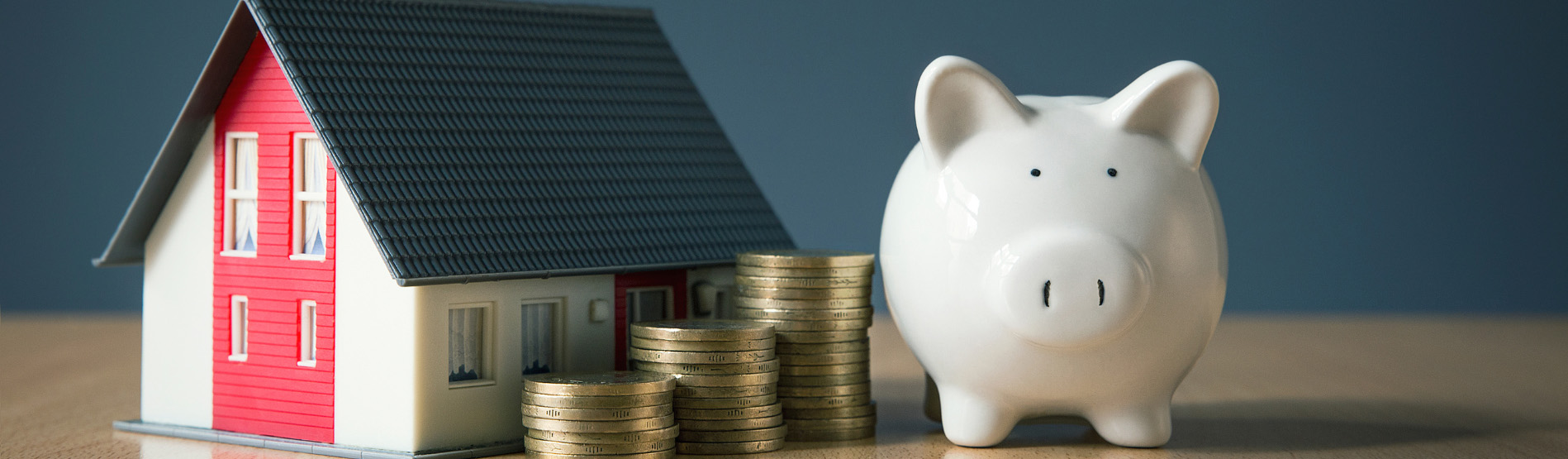 Piggy bank with coins and a toy house