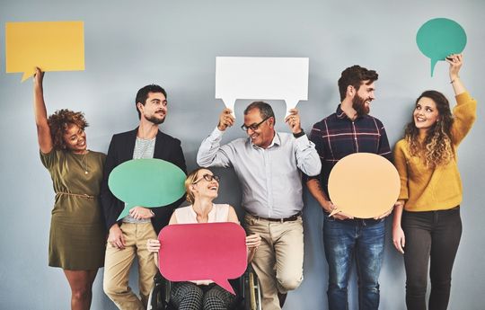 Students holding up speech bubbles in a row 